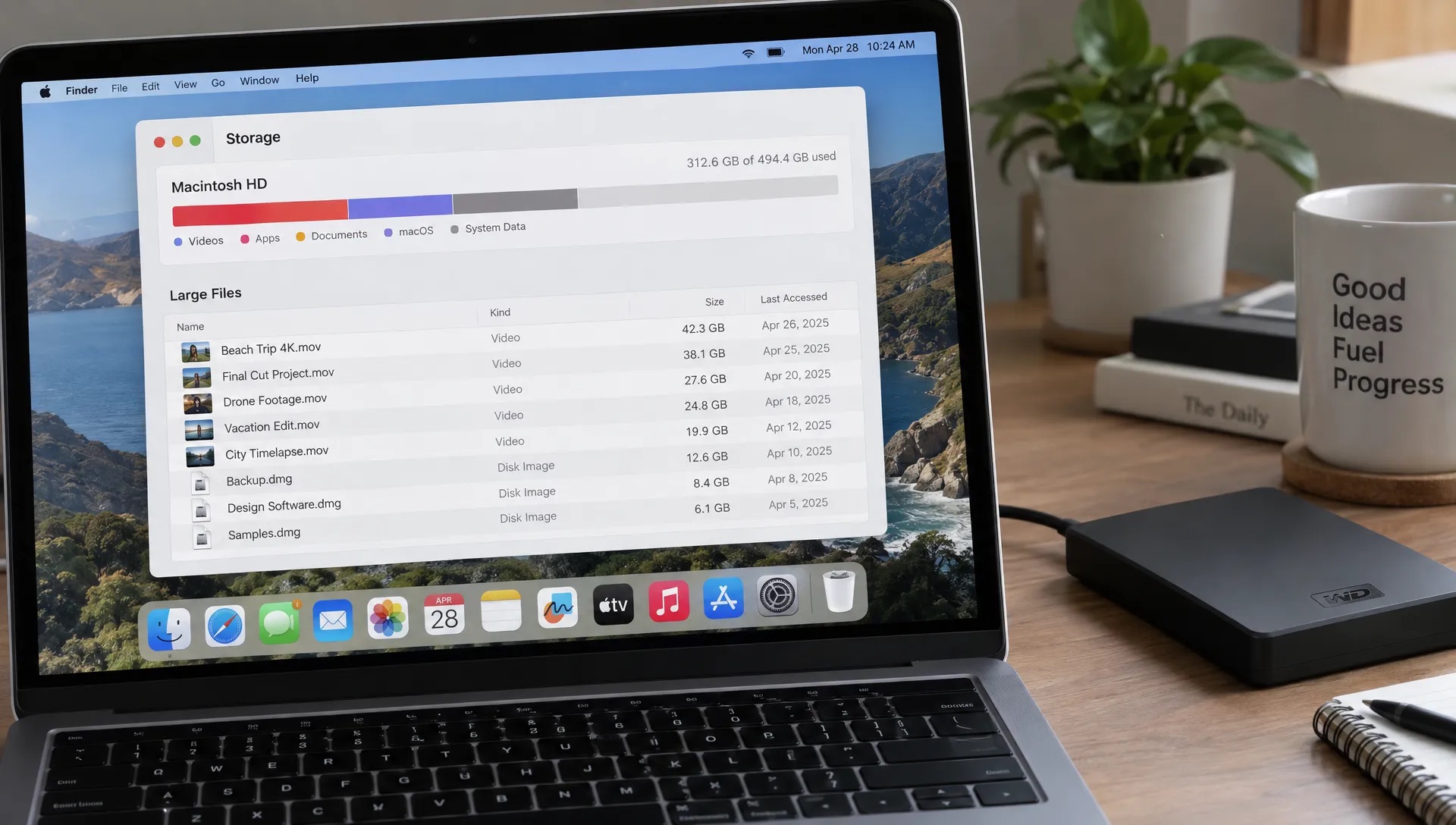 A Mac laptop displays large video files and disk images beside an external backup drive during a storage check.